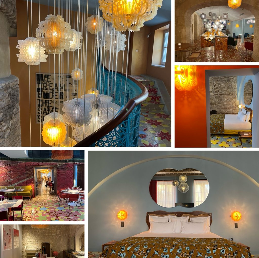 The image is a collage of photographs showcasing various rooms in a hotel or inn, featuring eclectic lighting fixtures and decor. In the top left frame, the room features a blue railing with hanging lights made from intricate white filigree, which are illuminated to create a warm glow. The walls are painted tan, adding to the cozy ambiance. The remaining frames display different rooms within the establishment, each with its own unique lighting scheme and decor. Some of these elements include: * A room with red brick walls. * A room with colorful floral-patterned flooring. * A room with a bed adorned in an orange patterned comforter. * A room with blue stone wall accents and a large round mirror above the bed. The overall atmosphere of the image is one of warmth and coziness, inviting viewers to relax and unwind within these comfortable spaces.