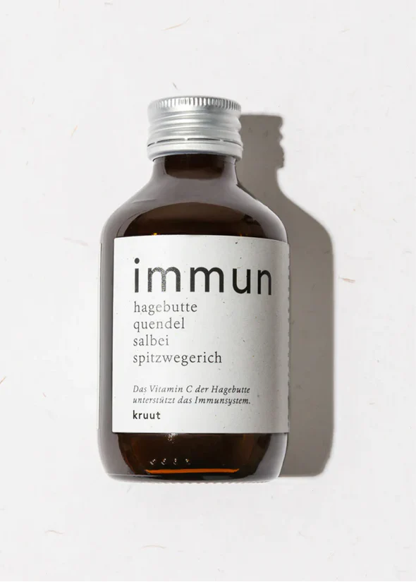 The image presents a bottle of "immun" supplement, likely an herbal or natural remedy, with a white label featuring German text. * **Bottle** + Color: Dark brown glass + Shape: Cylindrical with rounded shoulders + Size: Small to medium-sized + Cap: Silver screw-top * **Label** + Color: White + Text: - "immun" in large black font at the top - Smaller German text below, including "hagebutte quendel salbei spitzwegerich" - Additional text at the bottom, possibly indicating ingredients or instructions * **Background** + Color: White The image suggests that this product is a natural remedy intended to boost immunity, with the label highlighting its herbal ingredients.