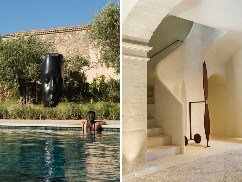 This image presents a striking diptych of two photographs, each showcasing distinct aspects of an outdoor setting. The left photograph features a large black sculpture resembling a human face in a shallow pool, with the back of a person's head visible behind it. The surrounding landscape is characterized by lush greenery and a tan stone wall, set against a clear blue sky. In contrast, the right photograph reveals an interior space with a curved white ceiling, featuring two tall sculptures on wheels standing upright against the wall. A staircase leads up to a second level, partially concealed from view.