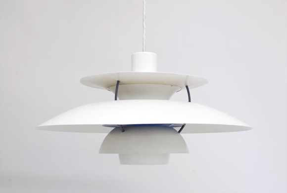 Alt tag: "Modern white pendant lamp with layered circular shades and minimalistic design, hanging against a plain background."