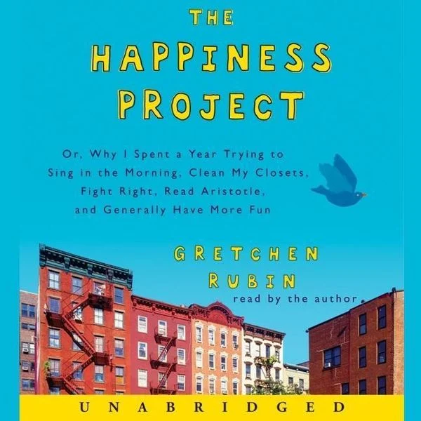 The image is the cover of an audiobook titled "THE HAPPINESS PROJECT" by Gretchen Rubin, featuring a cityscape with buildings and fire escapes against a blue sky. * The title "THE HAPPINESS PROJECT" is prominently displayed in yellow text at the top of the image. + The font is playful and casual, suggesting a lighthearted approach to the topic. + The use of all capital letters emphasizes the importance of happiness in the project. * A blue bird flying above the cityscape adds a sense of freedom and joy to the image. + The bird's presence implies that happiness can be found in everyday life, even amidst the hustle and bustle of urban living. + The blue color of the bird may also symbolize calmness and serenity. * A row of buildings with fire escapes on each side creates a sense of community and shared experience. + The buildings are depicted in various colors, adding visual interest to the image. + The fire escapes serve as a reminder that happiness can be found in the simple things, like taking care of oneself and others. Overall, the image effectively conveys the theme of the audiobook: finding happiness through everyday experiences and self-care. The use of bright colors, playful font, and uplifting imagery creates a positive and inspiring atmosphere, inviting listeners to embark on their own happiness project.
