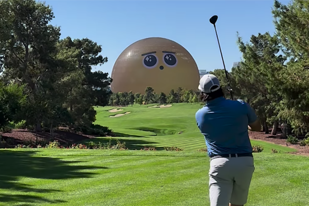 A golfer swings on a lush green course, with a large, cartoonish golden dome featuring big eyes in the background, under a clear blue sky.